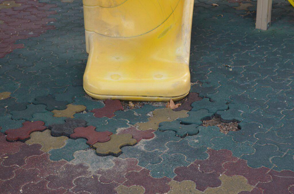 Выщербленная плитка у горки на площадке Золотая рыбка в Геленджике
